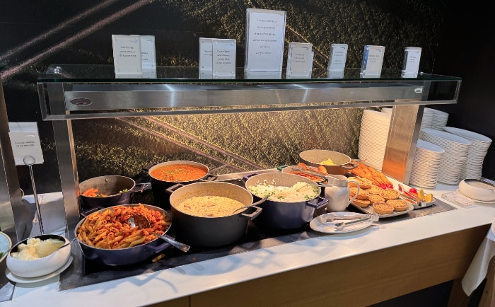 Station mit warmem Essen in der Galleries Club Lounge im Terminal 3 in Heathrow. &copy; ReiseInsider